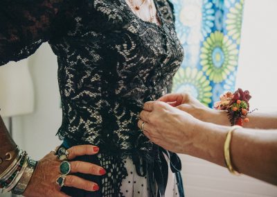 Habillage de la mariée pendant les préparatifs, ajustement de la robe – photographe mariage Mathis Vision