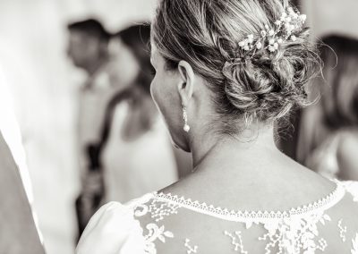 La mariée pendant les préparatifs, détail de la coiffure et de la robe en noir et blanc - photographe mariage Mathis Vision