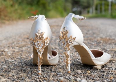 Talons de la mariée décorés de fleurs dorées lors des préparatifs de mariage - photographe mariage Mathis Vision
